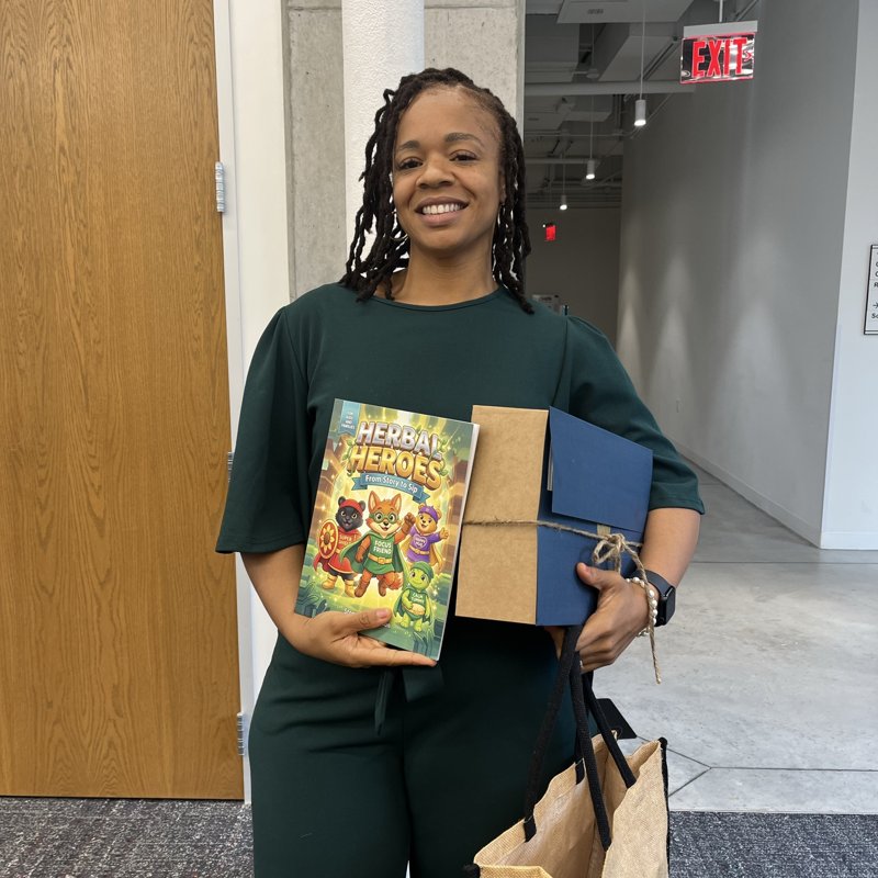Herbal Heroes founder holding the book and a wrapped bundle